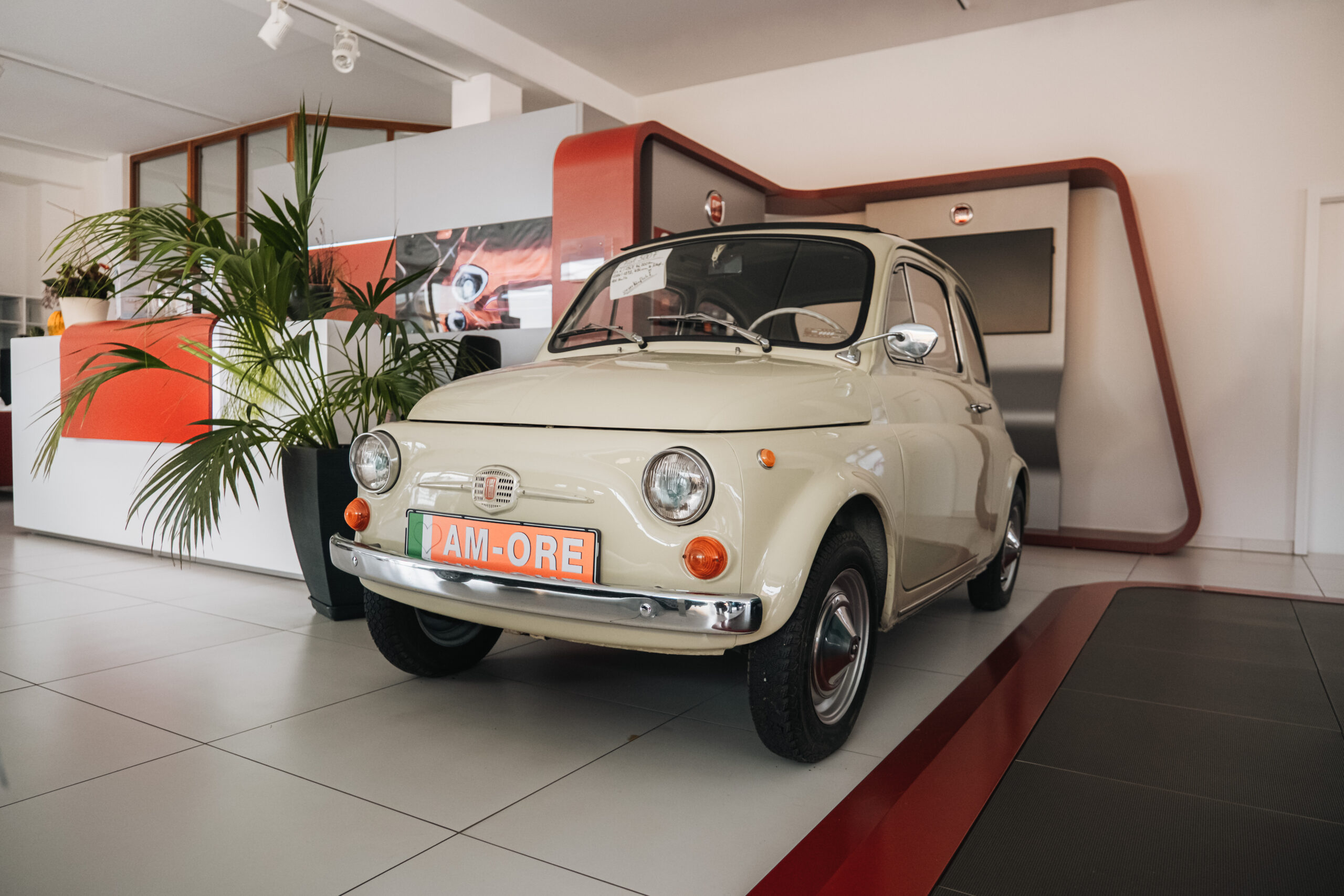 Ein weißer retro-Fiat 500 steht im Ausstellungsraum des Autohauses Weis.